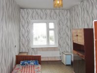 Просторная спальня, на полу линолеум, имеется диван и шкаф